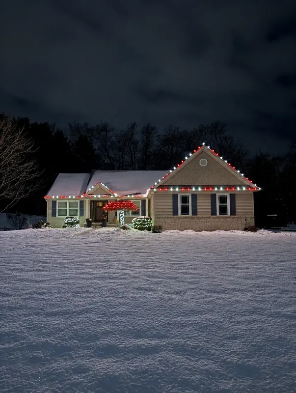 Snowy home with white and red roofline lights