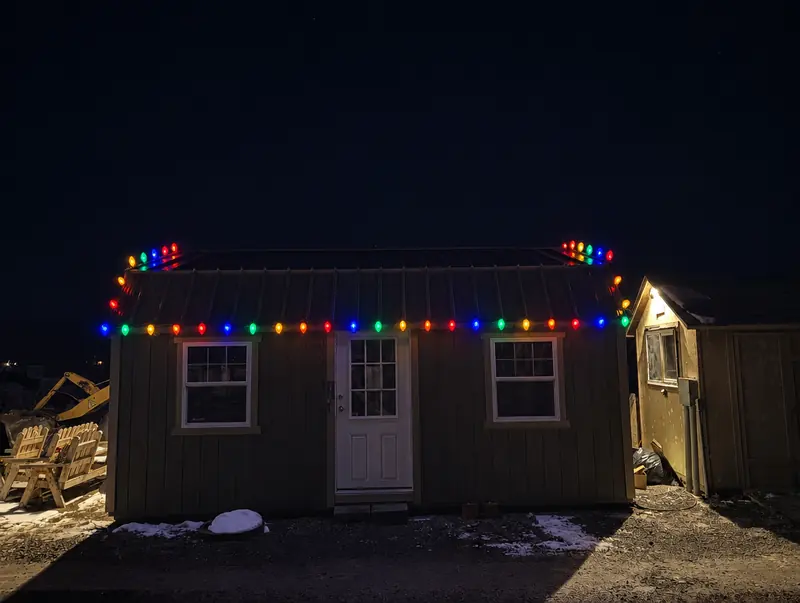 Shed with multicolor lights along the roofline and peaks